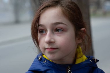 Mavi ceketli güzel, genç bir kadın şehir arka planında poz veriyor. Mavi bir ceket. 9 yaşında. 9 yaşında, mavi ceketli bir kız.