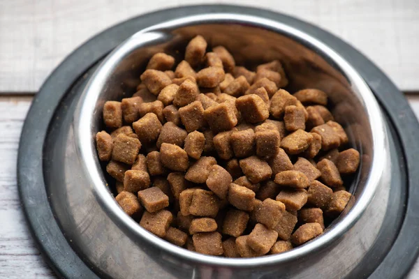 動物性食品 皿の中の猫や犬の食べ物 金属板の猫や犬の食べ物は 木製の床や窓の病気のプレート ペット用のペットフード 犬猫の健康のための乾燥食品 — ストック写真