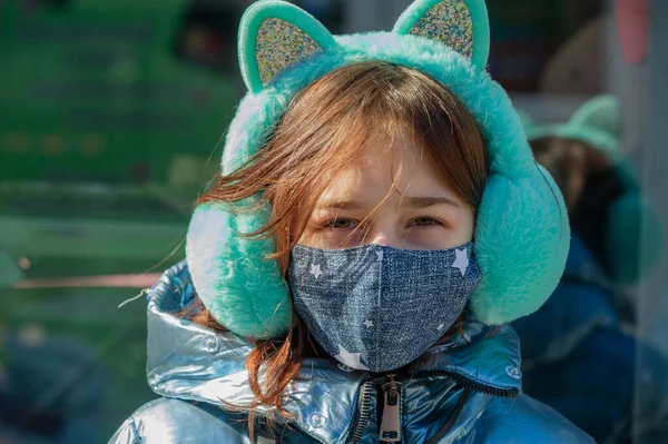 Woman in protective mask outdoors. Masked girl outdoors. Virus, mask, spring. Girl 9 years old. Street. Protection against viruses and bacteria. Medical respiratory mask. Epidemic. Protection