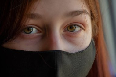 Koruyucu maskeli kadın. Dışarıdaki maskeli kız. Virüs. Kız 9 yaşında. Sokak. Virüs ve bakterilere karşı koruma. Tıbbi solunum maskesi. Salgın hastalık. Korunma. Coronavirus. Soğuk