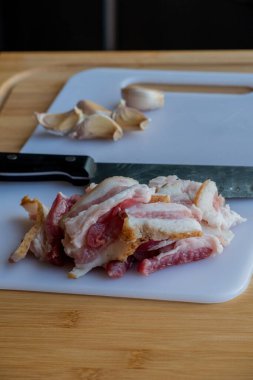Sarımsak ve pastırma ve sarımsak. Tahtadaki masada pastırma ve sarımsak. Yemek fotoğrafçılığı.