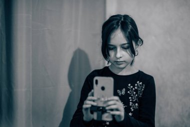 Mutlu genç bir kadın beyaz arka planda selfie çekiyor. Kız monopod ya da selfie çubuğuyla kendi videosunu çekiyor. Blogcu. Vlog. Kız internet ya da internet ağları için video çekiyor. Portre