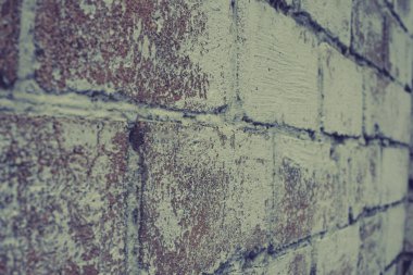 Eski, eski, kirli tuğla duvarın arka planında alçı ve doku soyuluyor. Tuğla duvar