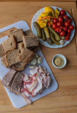 Sarımsaklı pastırma. Çavdar ekmekli sarımsak. Beyaz tahtada dilimlenmiş pastırma, sarımsak ve ekmek. Tuzlu sebzeler, sebze turşusu. Karnabahar, havuç, salatalık. Sebze. Yemek fotoğrafı. Sebzeler