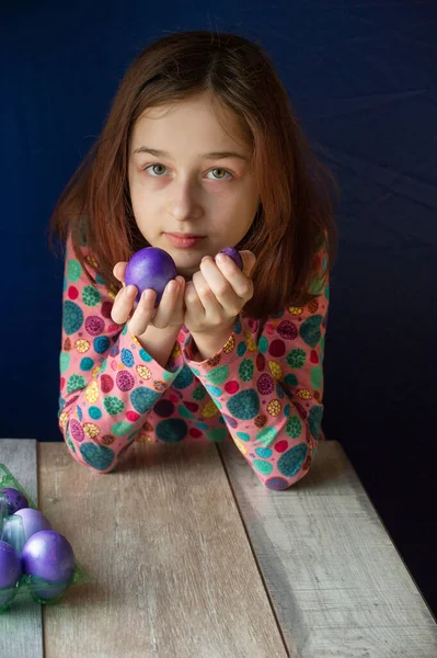 Mutlu Paskalyalar. Kız ve mor renkli yumurtalar. Paskalya gelenekleri. Ergen, kız 9 yaşında. Şarlatan bir kız. Puantiyeli elbise giymiş bir çocuk. Tatiller, ilkbahar