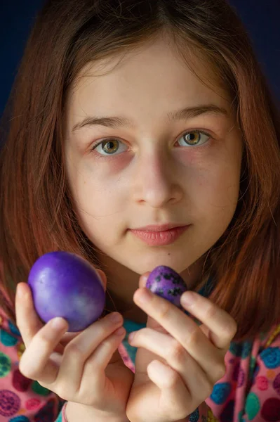 Mutlu Paskalyalar. Kız ve mor renkli yumurtalar. Paskalya gelenekleri. Ergen, kız 9 yaşında. Şarlatan bir kız. Puantiyeli elbise giymiş bir çocuk. Tatiller, ilkbahar