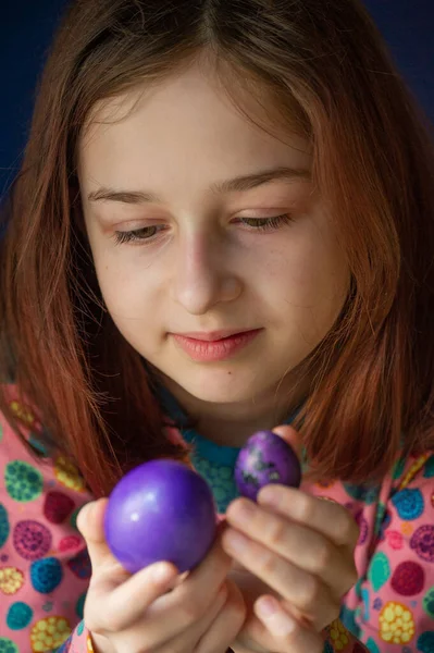 Mutlu Paskalyalar. Kız ve mor renkli yumurtalar. Paskalya gelenekleri. Ergen, kız 9 yaşında. Şarlatan bir kız. Puantiyeli elbise giymiş bir çocuk. Tatiller, ilkbahar