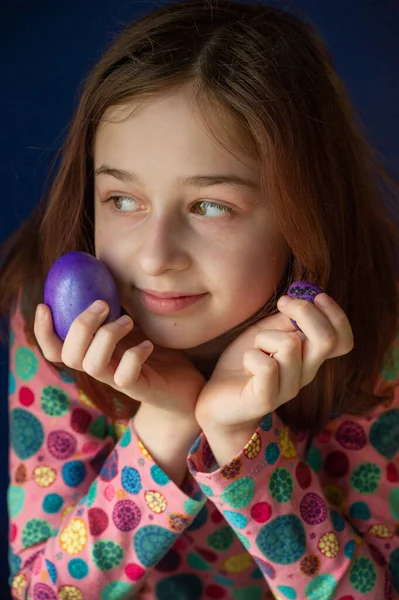 Mutlu Paskalyalar. Kız ve mor renkli yumurtalar. Paskalya gelenekleri. Ergen, kız 9 yaşında. Şarlatan bir kız. Puantiyeli elbise giymiş bir çocuk. Tatiller, ilkbahar