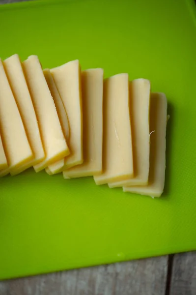 Krájený Sýr Řezací Desce Horní Pohled Nakrájený Tvrdý Sýr Zelenou — Stock fotografie
