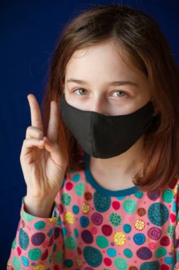 Solunum maskeli bir kız. Coronavirus, mavi arka planda maskeli bir kız. Çin 'de korona virüsü salgını, hastalık. Salgın hastalık. Genç, koronavirüs. Virüs. Maske.