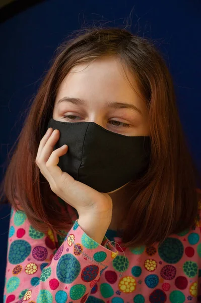 戴着黑色呼吸面具的女孩验尸官 一个戴着蓝色背景面具的女孩 标题关于日冕病毒在中国的爆发 流行病 青少年 验尸官 — 图库照片