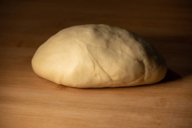 Mangır topu. Tahtada para var. Un, yumurta, hamurda un. Makarna, börek, börek..