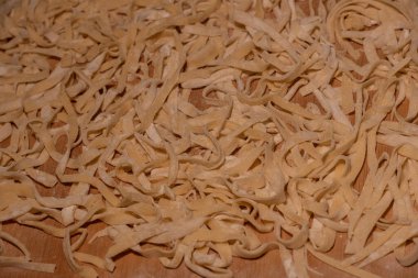 Çiğ sarı İtalyan makarnası. Ev yapımı erişte pişirme işlemi. Ev yapımı erişte. Un, su ve yumurtalı hamur. Pişirme un ürünleri.