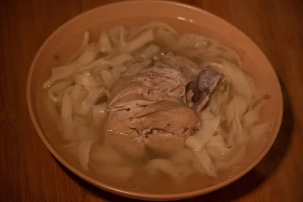 鸡肉面条汤 鸡汤和面汤放在桔子盘中的桔子桌布上 食品摄影 肉汤加面条 自制面条和肉汤 — 图库照片