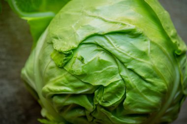 Tahta üzerinde lahana. Ahşap arka planda taze lahana. Vejetaryenlik, vejetaryenlik, yemek fotoğrafçılığı. Sebzeler, bahar. Beyaz lahana başı..