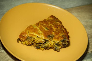 Ahşap arka planda lahana ve mantarlı turta. Mantarlı lahana turtası.