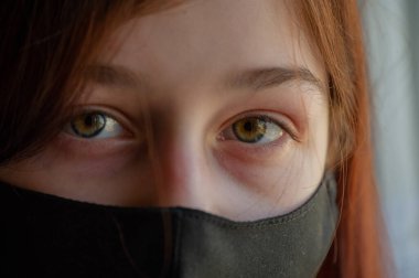 Koruyucu maskeli kadın. Dışarıdaki maskeli kız. Virüs. Kız 9 yaşında. Sokak. Virüs ve bakterilere karşı koruma. Tıbbi solunum maskesi. Salgın hastalık. Korunma. Coronavirus. Soğuk