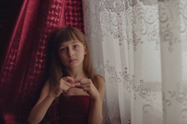 Liseli kız evde. Liseli bir kız evde kalır. 9 yaşında bir kızın portresi. Çocuk pencerenin yanına oturdu. Z jenerasyonunun çocukları. Küçük bir kızın portresi. Genç, koronavirüs, covid-19