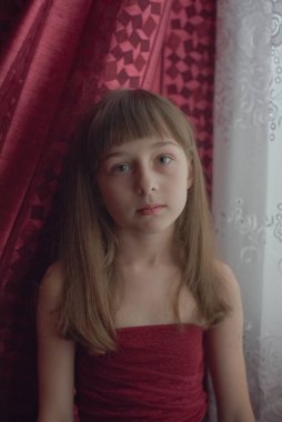 Liseli kız evde. Liseli bir kız evde kalır. 9 yaşında bir kızın portresi. Çocuk pencerenin yanına oturdu. Z jenerasyonunun çocukları. Küçük bir kızın portresi. Genç, koronavirüs, covid-19