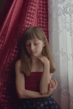 Liseli kız evde. Liseli bir kız evde kalır. 9 yaşında bir kızın portresi. Çocuk pencerenin yanına oturdu. Z jenerasyonunun çocukları. Küçük bir kızın portresi. Genç, koronavirüs, covid-19