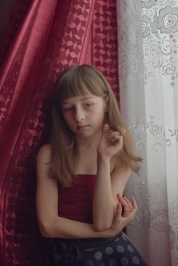 Liseli kız evde. Liseli bir kız evde kalır. 9 yaşında bir kızın portresi. Çocuk pencerenin yanına oturdu. Z jenerasyonunun çocukları. Küçük bir kızın portresi. Genç, koronavirüs, covid-19