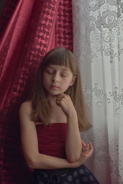 Liseli kız evde. Liseli bir kız evde kalır. 9 yaşında bir kızın portresi. Çocuk pencerenin yanına oturdu. Z jenerasyonunun çocukları. Küçük bir kızın portresi. Genç, koronavirüs, covid-19