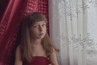 Liseli kız evde. Liseli bir kız evde kalır. 9 yaşında bir kızın portresi. Çocuk pencerenin yanına oturdu. Z jenerasyonunun çocukları. Küçük bir kızın portresi. Genç, koronavirüs, covid-19