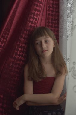 Liseli kız evde. Liseli bir kız evde kalır. 9 yaşında bir kızın portresi. Çocuk pencerenin yanına oturdu. Z jenerasyonunun çocukları. Küçük bir kızın portresi. Genç, koronavirüs, covid-19