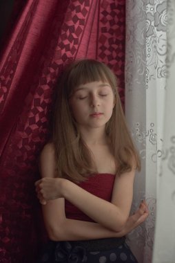 Liseli kız evde. Liseli bir kız evde kalır. 9 yaşında bir kızın portresi. Çocuk pencerenin yanına oturdu. Z jenerasyonunun çocukları. Küçük bir kızın portresi. Genç, koronavirüs, covid-19