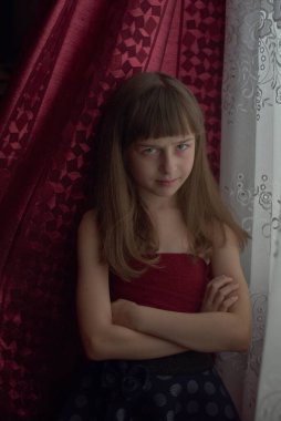 Liseli kız evde. Liseli bir kız evde kalır. 9 yaşında bir kızın portresi. Çocuk pencerenin yanına oturdu. Z jenerasyonunun çocukları. Küçük bir kızın portresi. Genç, koronavirüs, covid-19