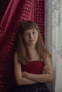 Liseli kız evde. Liseli bir kız evde kalır. 9 yaşında bir kızın portresi. Çocuk pencerenin yanına oturdu. Z jenerasyonunun çocukları. Küçük bir kızın portresi. Genç, koronavirüs, covid-19