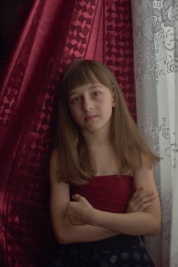 Liseli kız evde. Liseli bir kız evde kalır. 9 yaşında bir kızın portresi. Çocuk pencerenin yanına oturdu. Z jenerasyonunun çocukları. Küçük bir kızın portresi. Genç, koronavirüs, covid-19