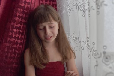 Liseli kız evde. Liseli bir kız evde kalır. 9 yaşında bir kızın portresi. Çocuk pencerenin yanına oturdu. Z jenerasyonunun çocukları. Küçük bir kızın portresi. Genç, koronavirüs, covid-19