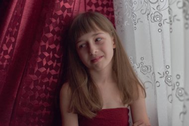 Liseli kız evde. Liseli bir kız evde kalır. 9 yaşında bir kızın portresi. Çocuk pencerenin yanına oturdu. Z jenerasyonunun çocukları. Küçük bir kızın portresi. Genç, koronavirüs, covid-19