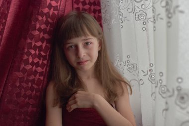 Liseli kız evde. Liseli bir kız evde kalır. 9 yaşında bir kızın portresi. Çocuk pencerenin yanına oturdu. Z jenerasyonunun çocukları. Küçük bir kızın portresi. Genç, koronavirüs, covid-19