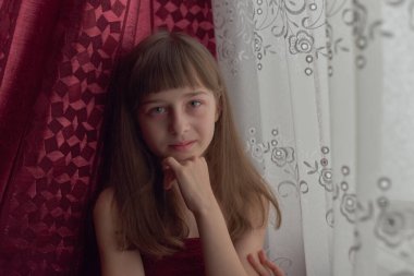 Liseli kız evde. Liseli bir kız evde kalır. 9 yaşında bir kızın portresi. Çocuk pencerenin yanına oturdu. Z jenerasyonunun çocukları. Küçük bir kızın portresi. Genç, koronavirüs, covid-19