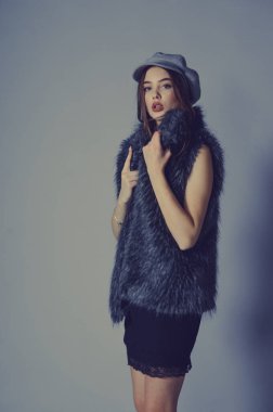 Portre. Güzel bir genç kadının muhteşem portresi. Mükemmel yüz güzel kız portresi. Esmer kız. Gri şapkalı kız. Küçük siyah elbise. Sahte kürklü yelekli bir kız. Stüdyoda bir kız