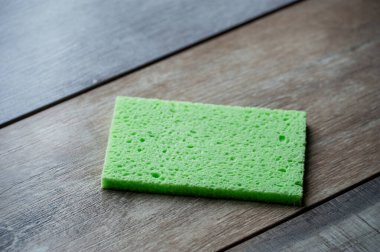 Selüloz sünger mutfak objeleri ahşap doku arka planında. Selüloz peçete masanın üstünde..