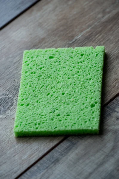 Cellulose sponge kitchen objects on the wood texture background. Cellulose napkin on the table.