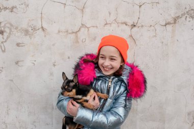 Kız ve köpek. Chihuahua köpeği olan küçük bir kız. Bir kızın elinde bir köpek yavrusu. Kollarında evcil hayvanıyla bir kız. Siyah, kahverengi ve beyaz Chihuahua. Çocuklar hayvanlarını sever. Köpekli gençler.