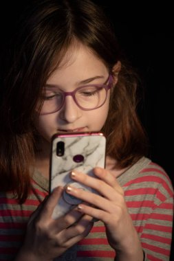 Elinde akıllı telefon olan bir kız. 9 yaşında telefonlu bir kız..