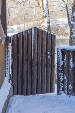 Çıkış, giriş konsepti. Kar taneli eski ahşap doku. Kapı, kış. Bir kış gününde kapı
