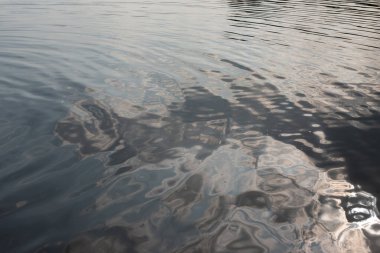 Nehirdeki suyun yüzeyinde küçük dalgalar.