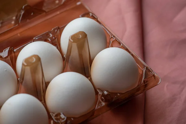 concept of natural eggs. A tray of eggs on a white and pink background. eco tray with testicles. minimalistic trend, top view. Egg tray. Egg, Chicken Egg. Eco product, organic food. Easter. eggs, eco