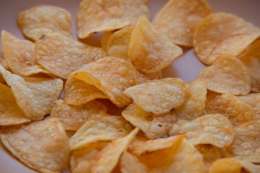 Patates cipsli bir kaseye yakın çekim. Tabakta patates cipsi. Yemek fotoğrafçılığı. Cips makro fotoğraf. Patates yemeği, atıştırmalık.,