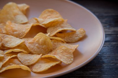 Patates cipsli bir kaseye yakın çekim. Tabakta patates cipsi. Yemek fotoğrafçılığı. Cips makro fotoğraf. Patates yemeği, atıştırmalık.,