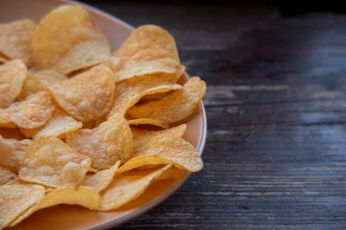 Patates cipsli bir kaseye yakın çekim. Tabakta patates cipsi. Yemek fotoğrafçılığı. Cips makro fotoğraf. Patates yemeği, atıştırmalık.,