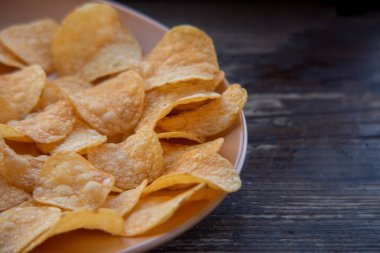 Patates cipsli bir kaseye yakın çekim. Tabakta patates cipsi. Yemek fotoğrafçılığı. Cips makro fotoğraf. Patates yemeği, atıştırmalık.,