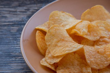 Patates cipsli bir kaseye yakın çekim. Tabakta patates cipsi. Yemek fotoğrafçılığı. Cips makro fotoğraf. Patates yemeği, atıştırmalık.,