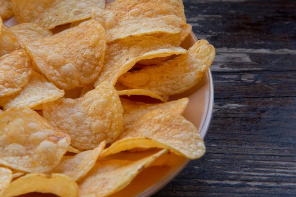 closeup of a bowl with potato chips. Potato chips on a plate. Food photography. Chips macro photo. Potato dish, snack,